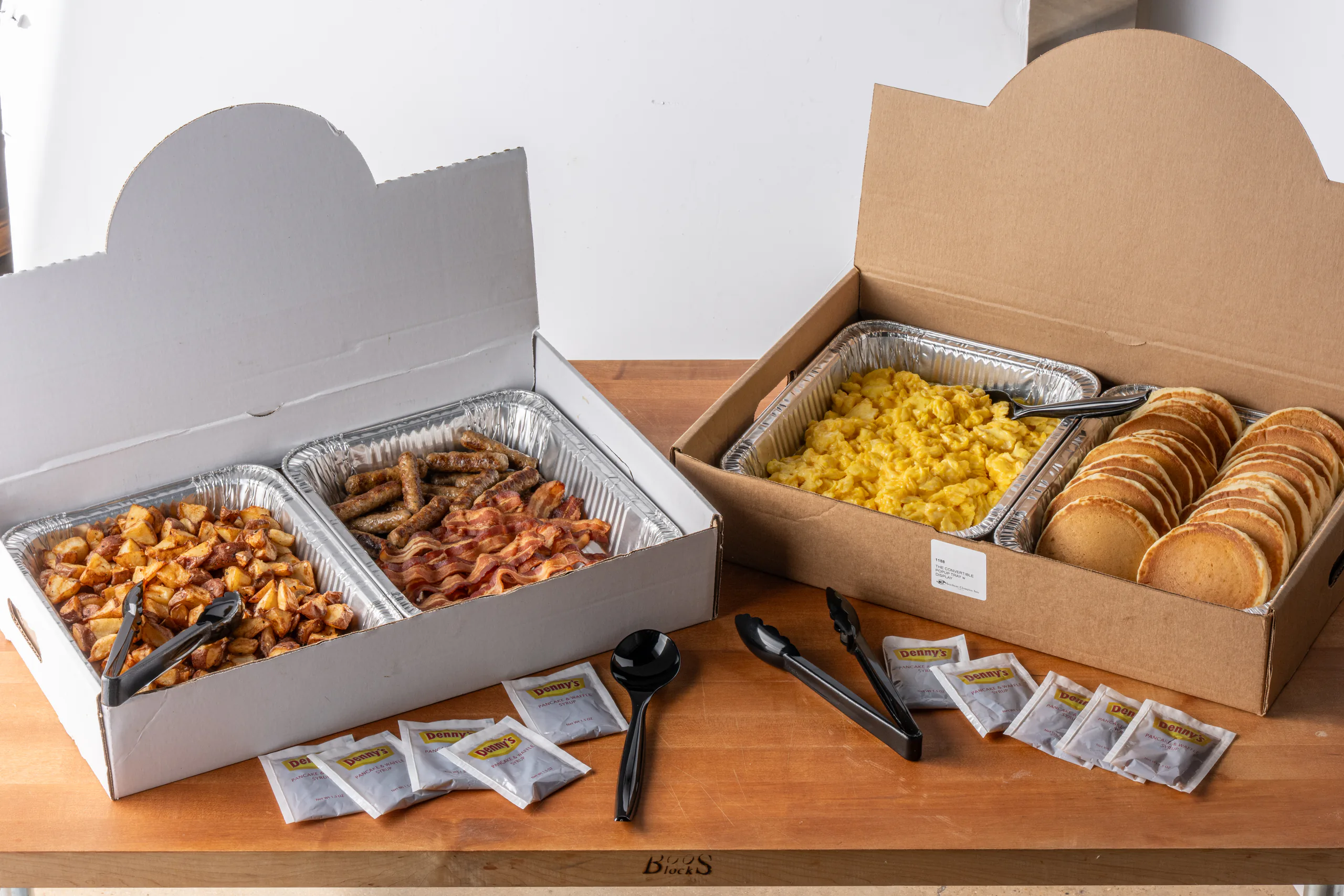 Client-supplied Denny's catering breakfast trays and packaging photographed for the launch materials.