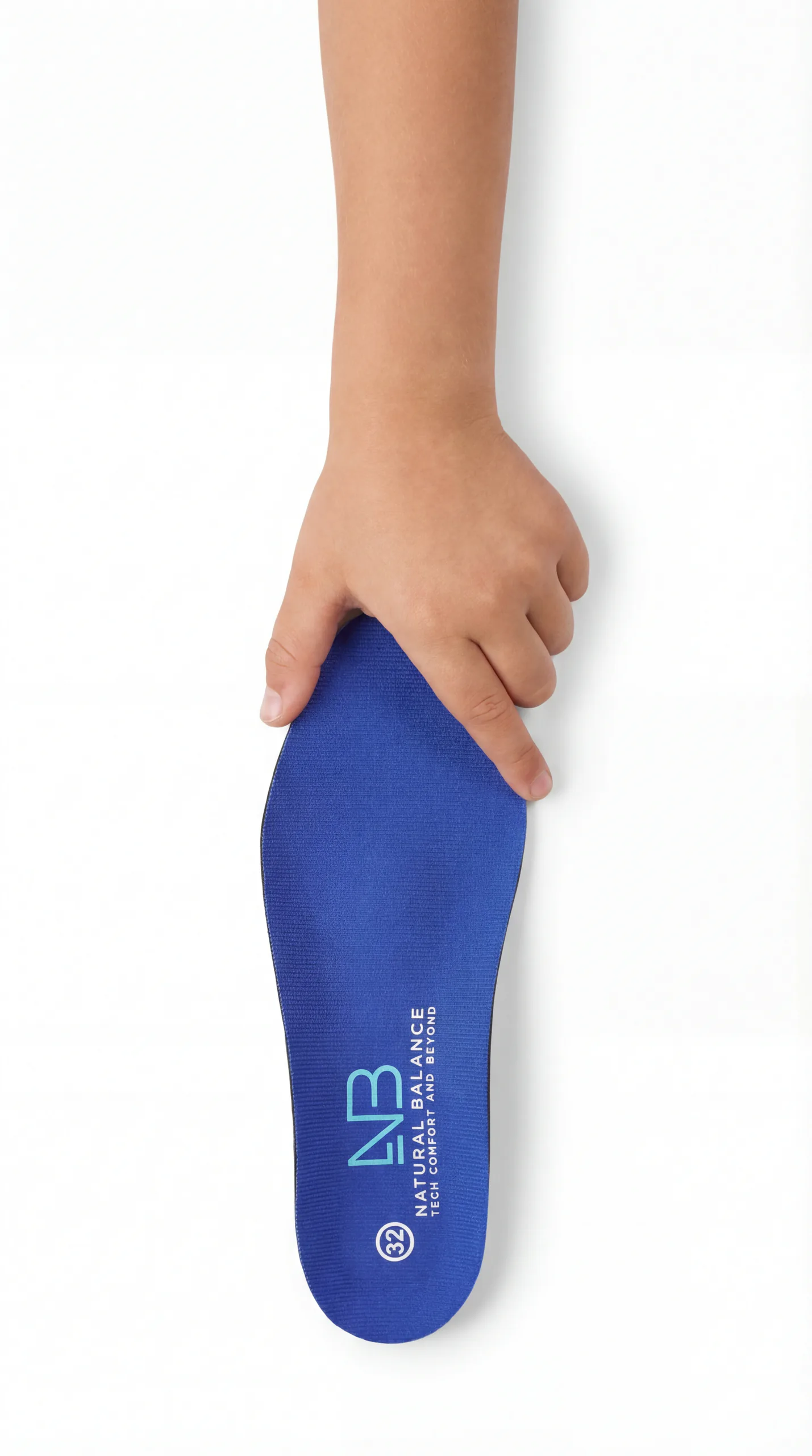 A child's hand holding a blue Natural Balance insole.
