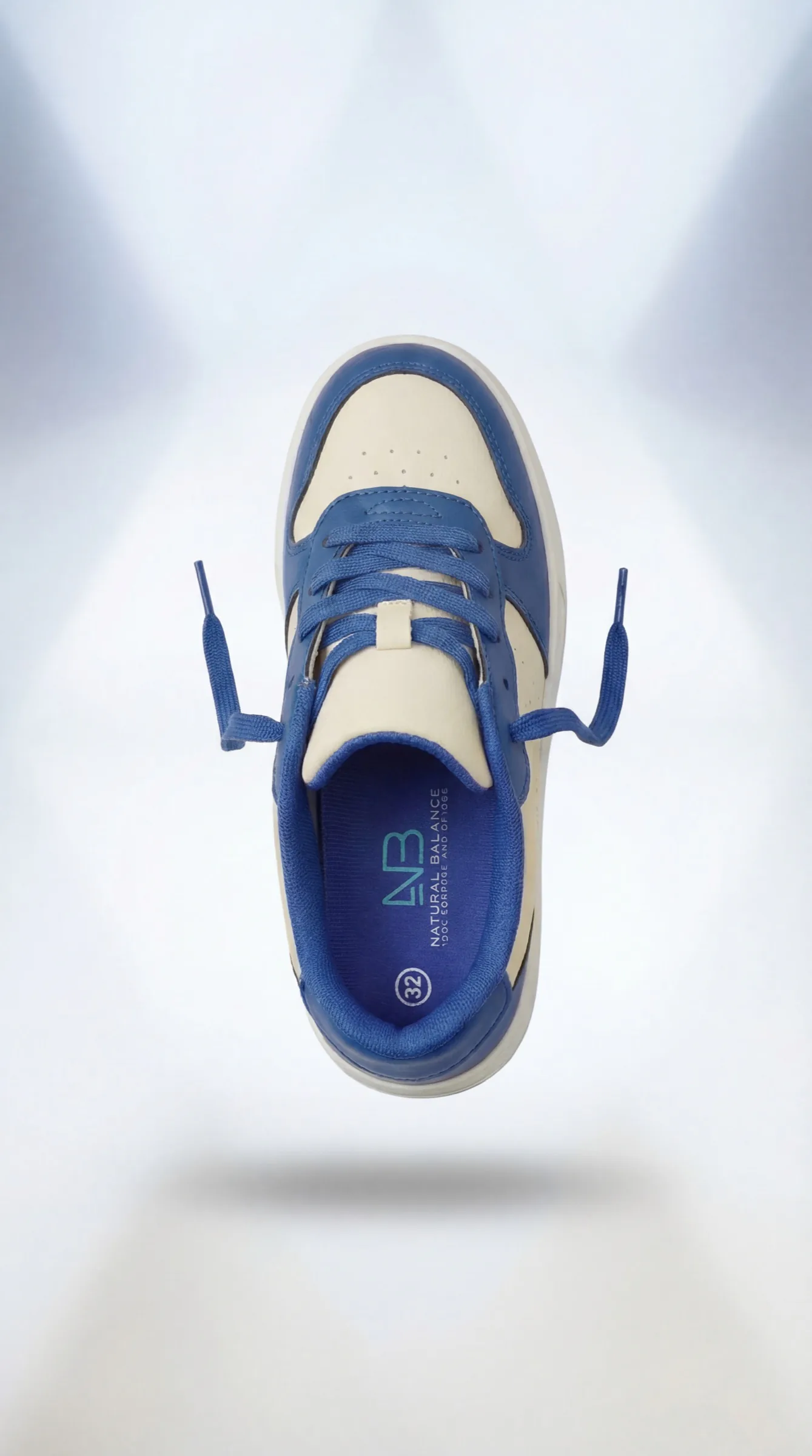 A blue-and-cream Natural Balance shoe floating above its shadow.